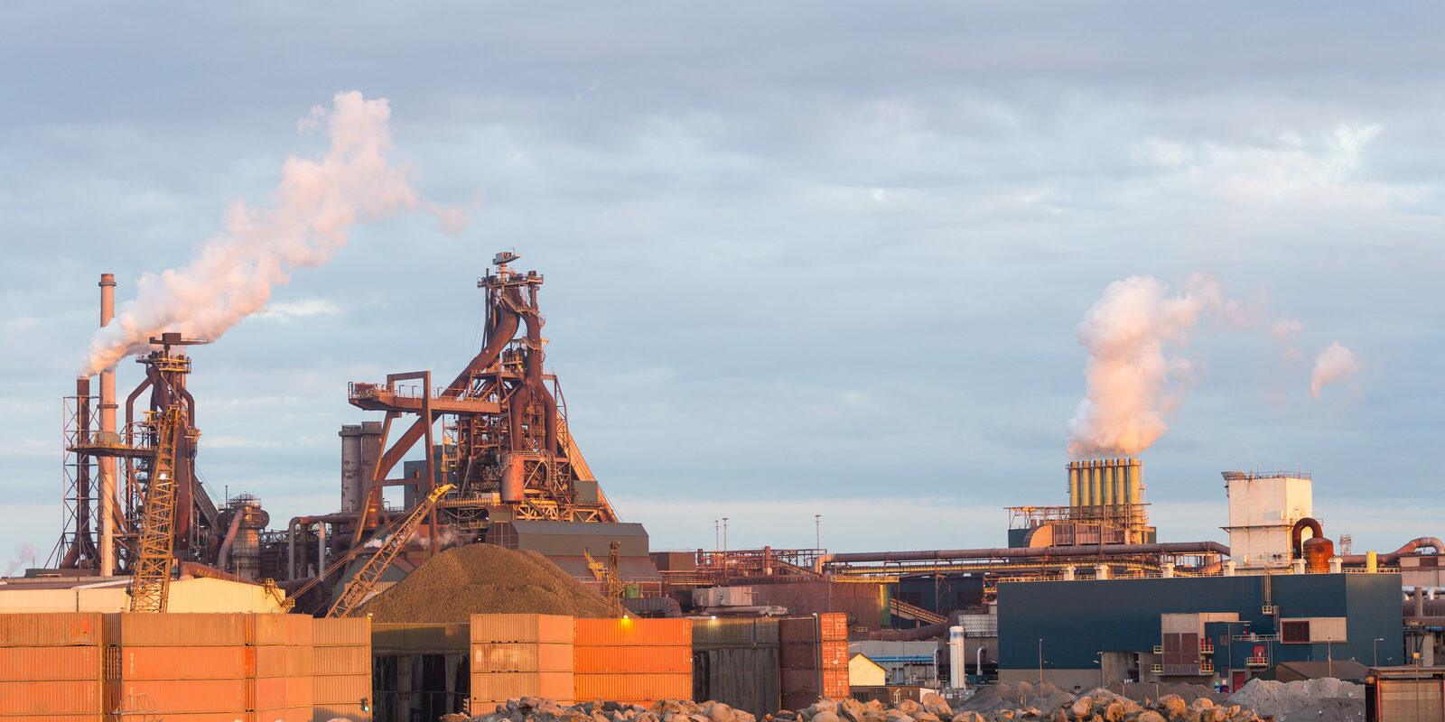 Old steel factory with smokestacks and chimney emissions